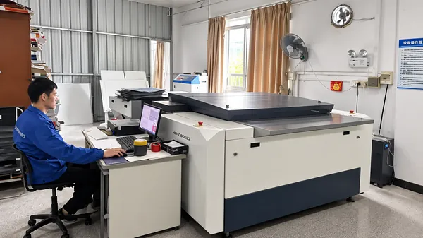 Operator at a computer-to-plate machine preparing printing plates